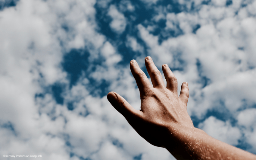 Eine Hand reckt sich in den Himmel